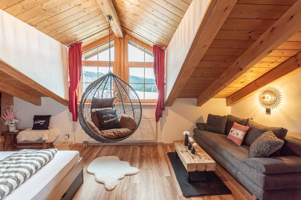 a living room with a couch and a swing at Bienenhaus #Bergblick im Sonnenhof in Seeg