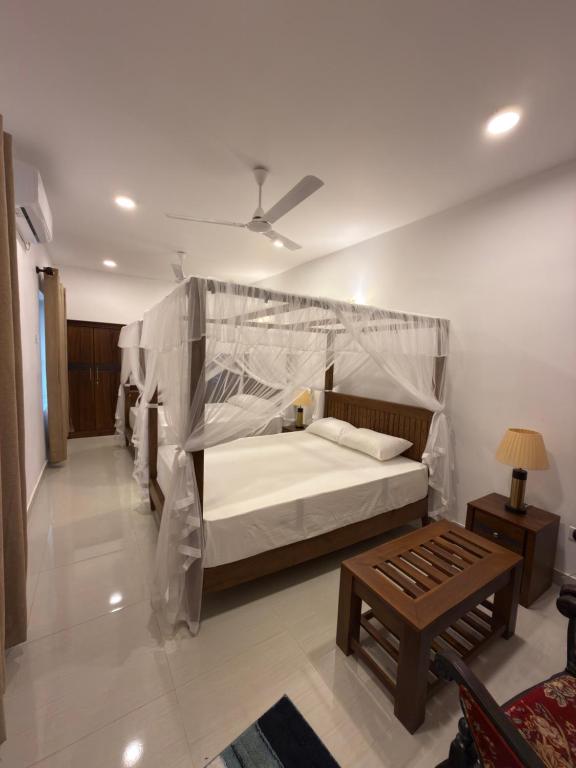une chambre avec un grand lit avec une moustiquaire dans l'établissement Villa Sandakelum Luxury, à Weligama