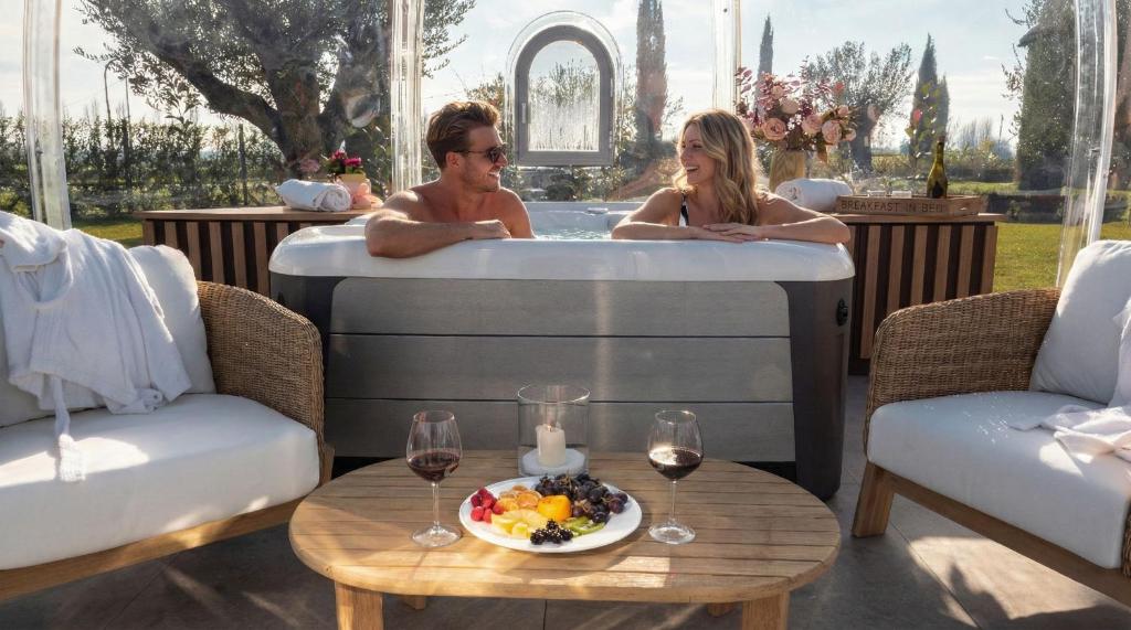 Un hombre y una mujer en una bañera con un plato de comida. en Borgo Degli Angeli Resort e Spa, en San Vitale