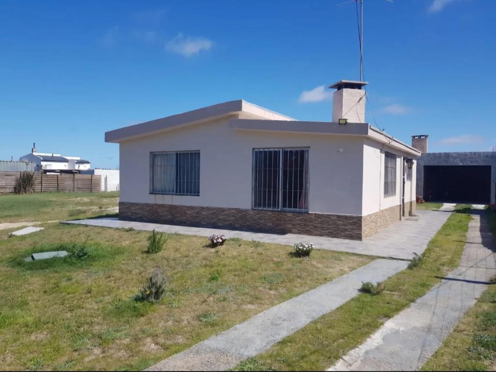 ein kleines weißes Haus auf einem Feld mit einer Auffahrt in der Unterkunft Casa en Cuchilla Alta Biarritz in Cuchilla Alta