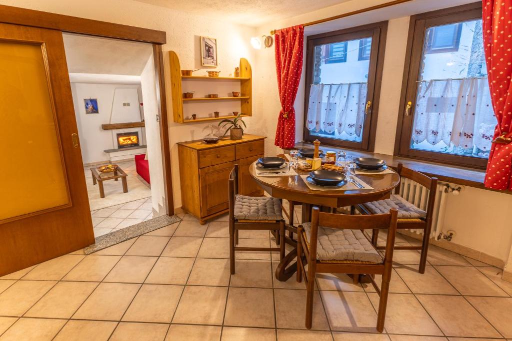 een keuken met een tafel, stoelen en ramen bij Maison Plan de Dieu in Saint-Pierre