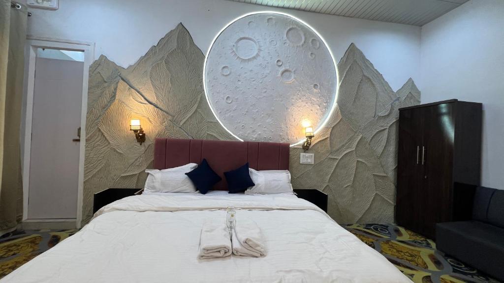 een slaapkamer met een bed met een groot schilderij aan de muur bij AERON kabila Resort in Sītāpur