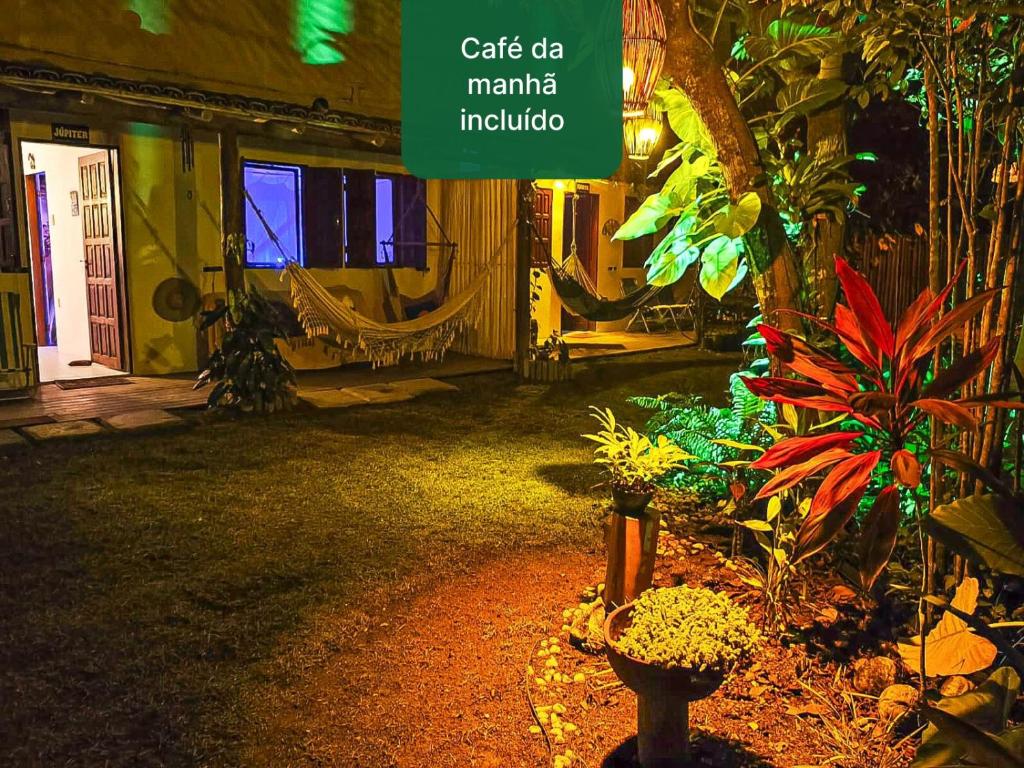um jardim à noite com uma placa que diz café da marina indigo em Bungalos Orion a 150 m Praia do Espelho em Praia do Espelho