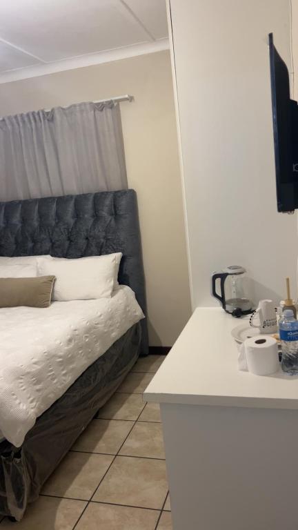 a bed with a black headboard in a room at Tesco Accommodation in Gqeberha