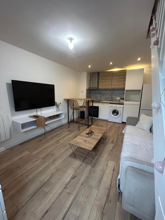 una sala de estar con un sofá y una mesa en Maison cocooning, en Saint-Sébastien-sur-Loire