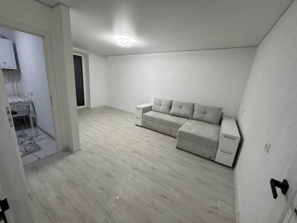 a living room with a couch in a white room at Apartament cu 1 camera in Soroca