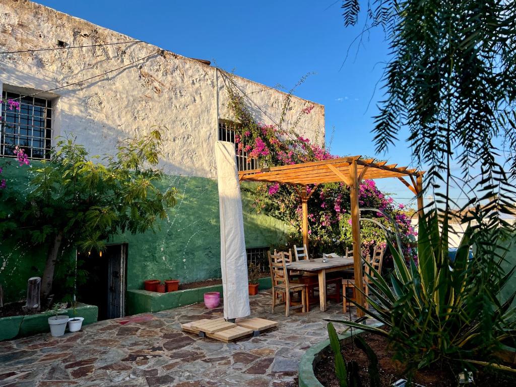 un patio con una mesa y una sombrilla en Casa Gatti - Autentica Casa Canaria nel cuore di Lanzarote, en Tiagua