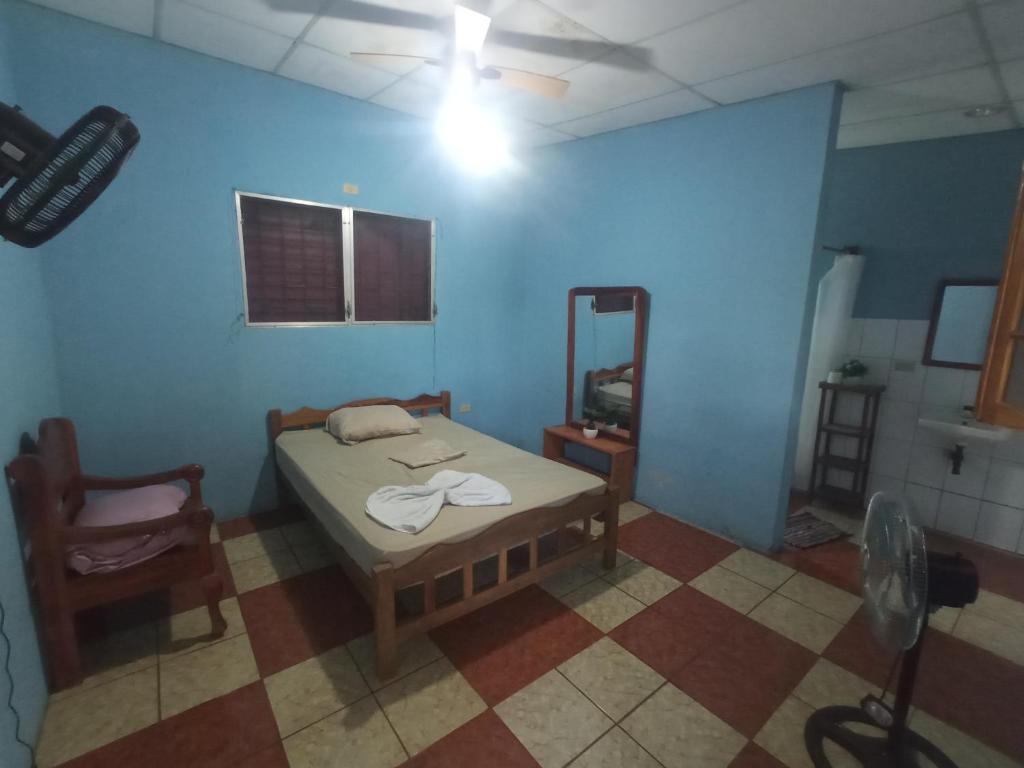 Habitación con cama y silla. en hostal Casa pura vida, en Rivas