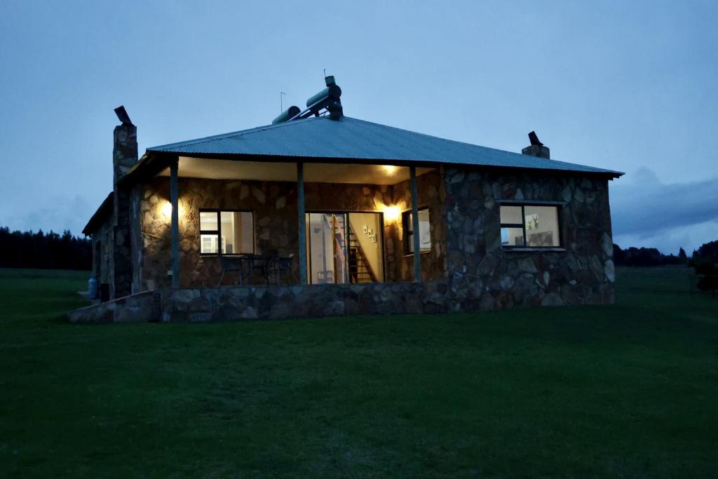 a small stone house with lights on it in a field at Uitvlugt Ponds in Dullstroom
