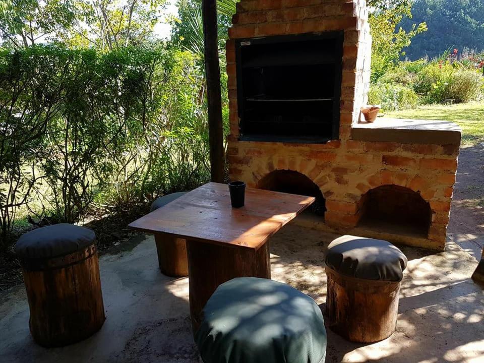 a table and stools in front of a brick oven at Mountain Haven Kaapsehoop in Kaapsehoop