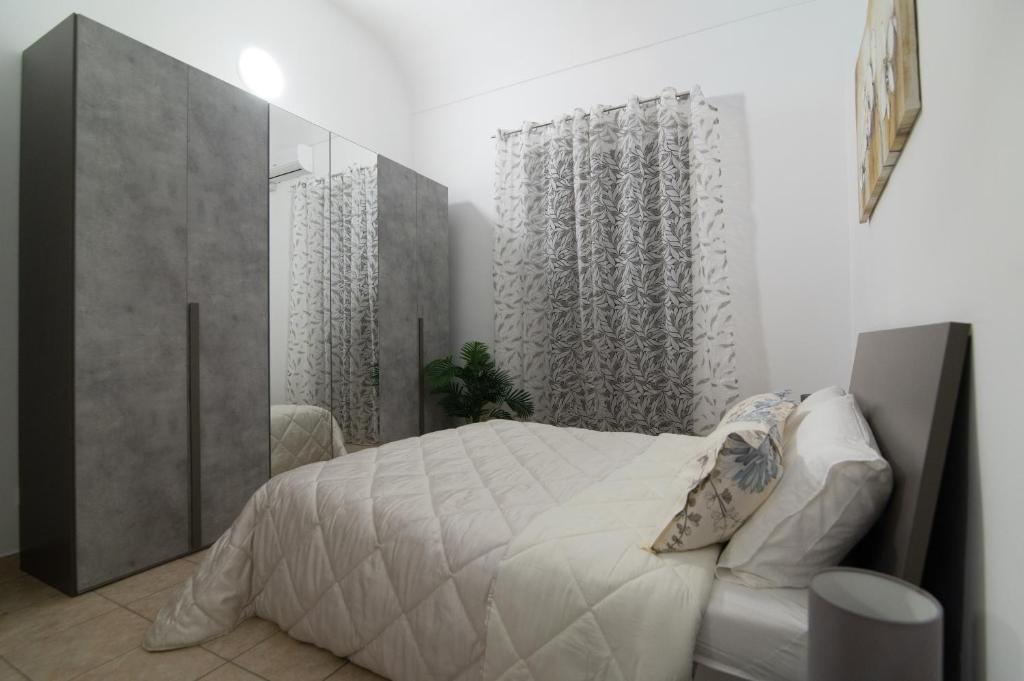 a bedroom with a large white bed and a window at Dimora Saracena in Adrano