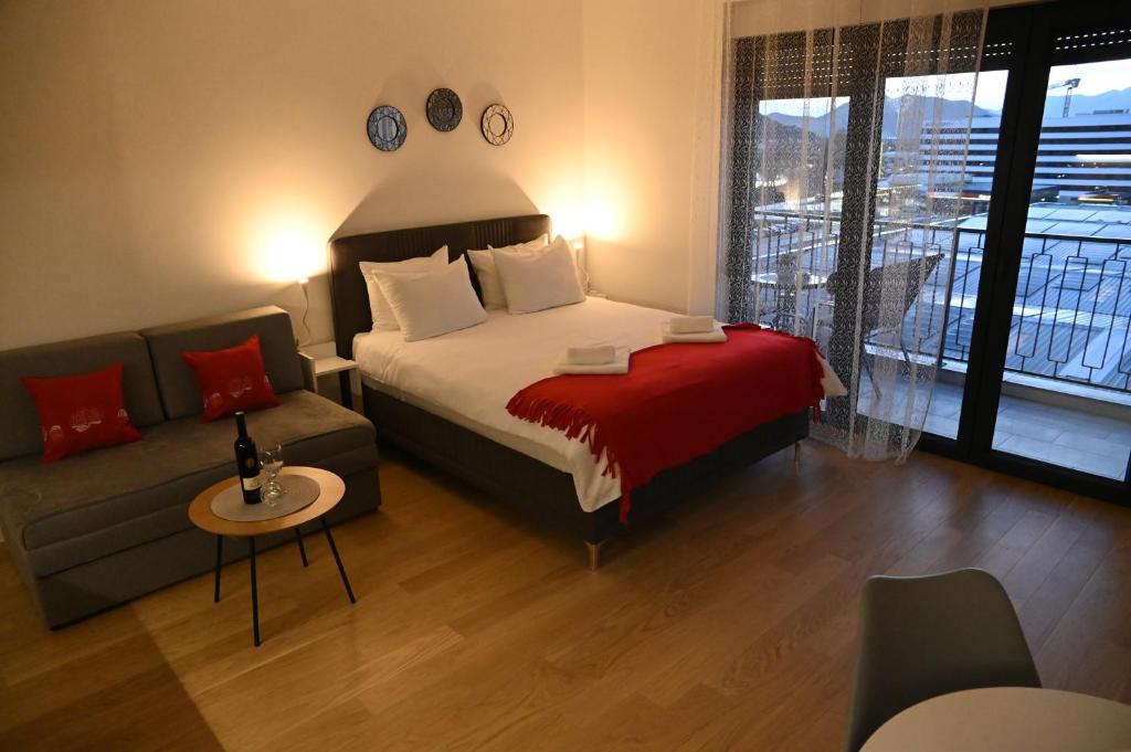 a hotel room with a bed and a couch at Apartman Perfect in Trebinje