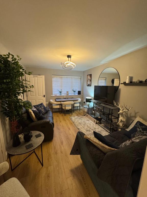 a living room with a couch and a table at Willow Cottage in North Muskham