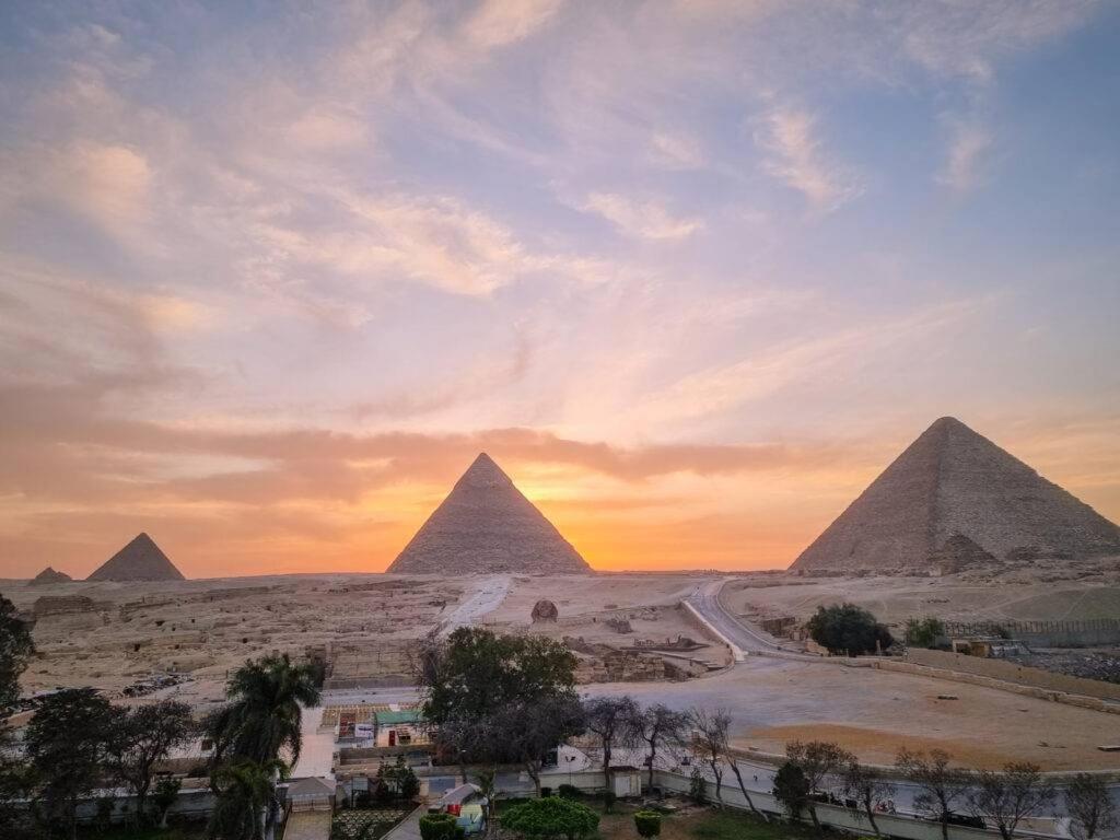 una vista de las pirámides de Giba al atardecer en Giza Pyramids Hotel, en El Cairo