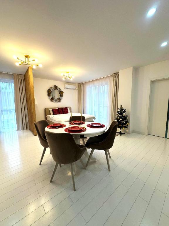 a living room with a dining room table and chairs at Studio Vivo Residence in Baia Mare