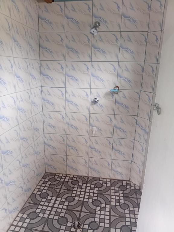 Un baño con ducha con azulejos blancos. en Emma's Homestay Explorer, en Taveuni