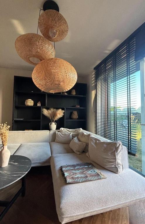 a living room with a couch and two large lights at BOHO Oasis Radom - Dom z parkingiem in Radom