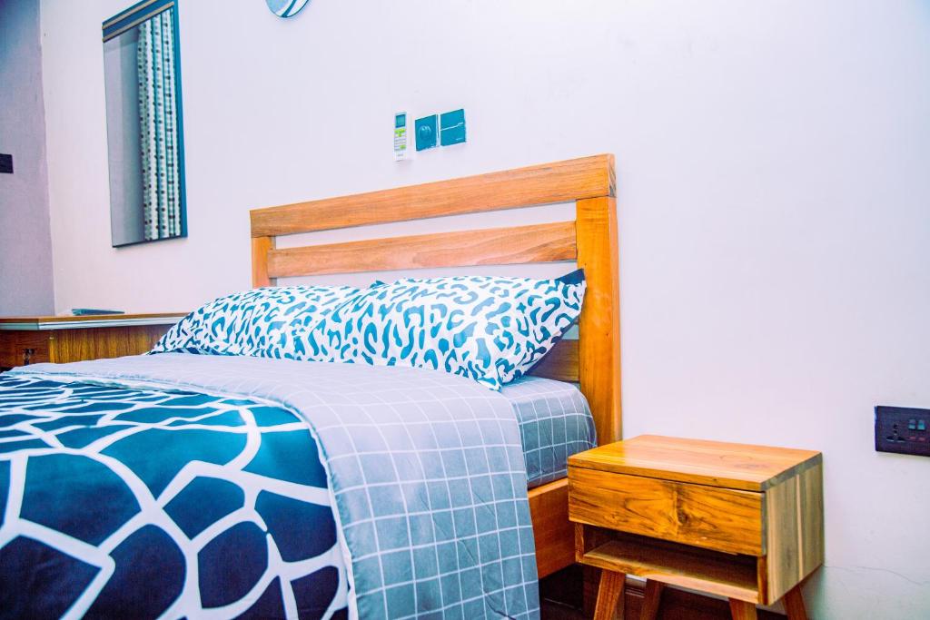 Aubri Homes في آكرا: غرفة نوم بسرير من اللوح الخشبي وطاولة