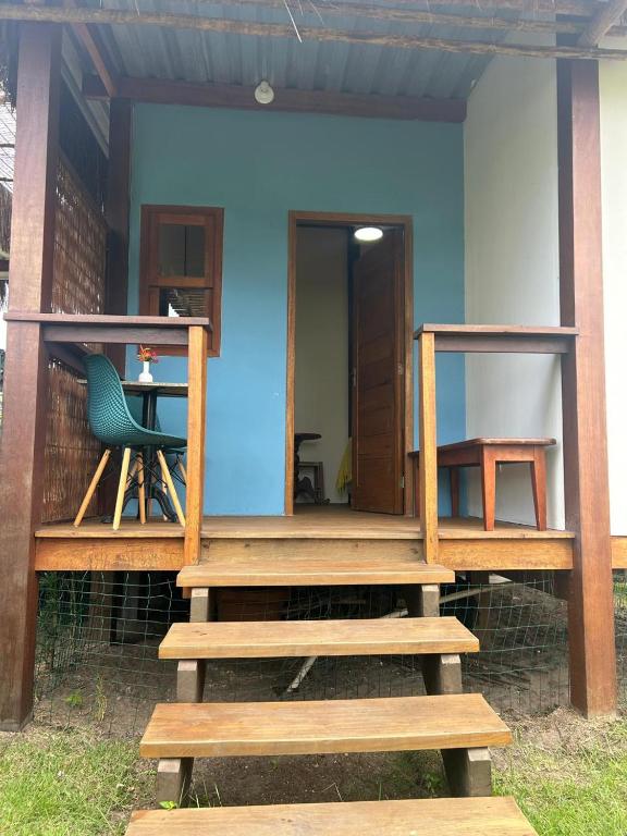 a house with a deck with a table and a chair at Suíte da Alê in Marau