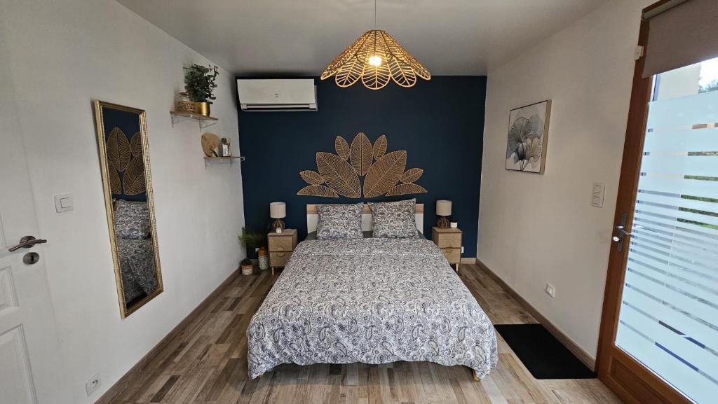 a bedroom with a bed and a chandelier at Chambre privé climatisé in Vertaizon