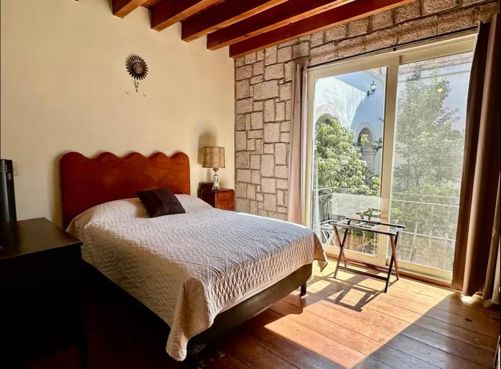 a bedroom with a bed and a large window at Departamento centrico in Durango