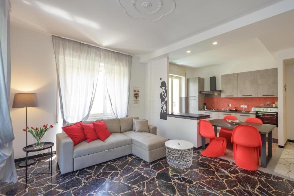 Casa celine moderna, relax, comoda alle spiagge e negozi في شيافاري: غرفة معيشة مع أريكة وطاولة مع كراسي حمراء