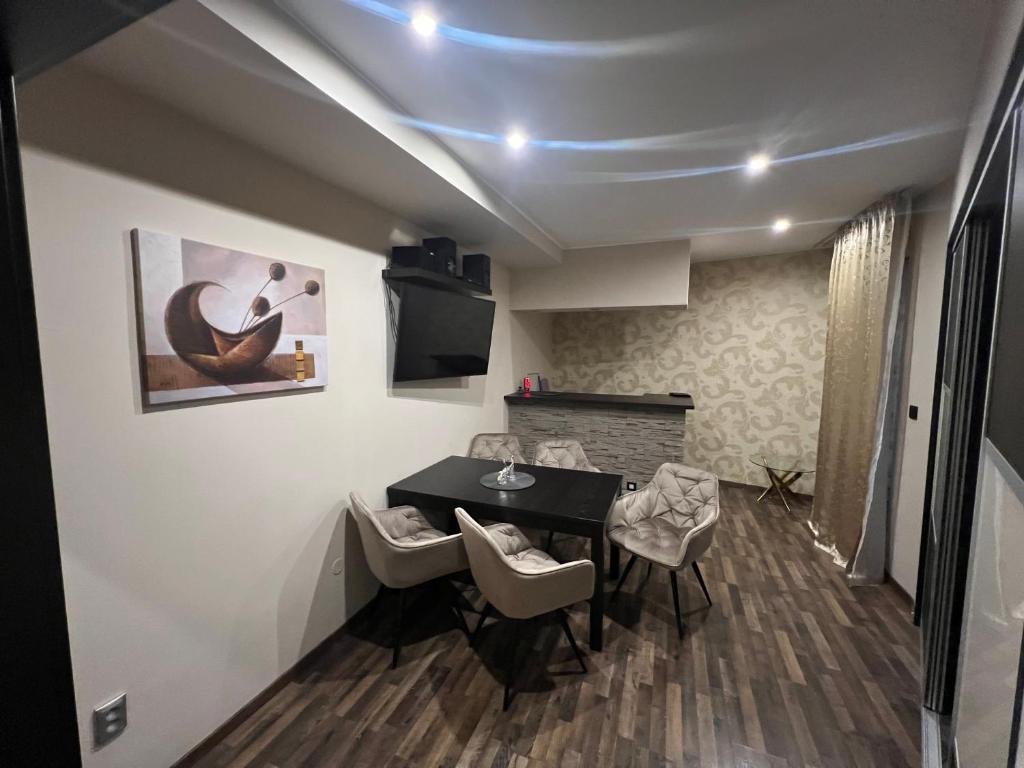 a room with a table and chairs and a fireplace at Šafran Apartment LUX in Donovaly