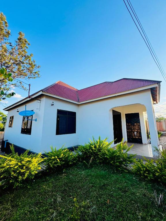 a white house with a red roof at CnRAirBnB in Iringa