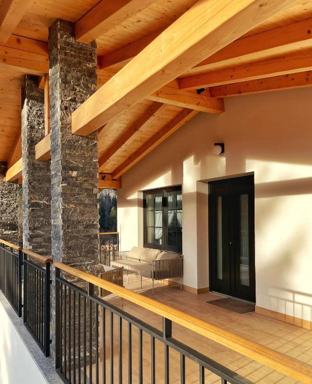 a porch with a stone wall and wooden ceiling at Cabana Roua in Borsa
