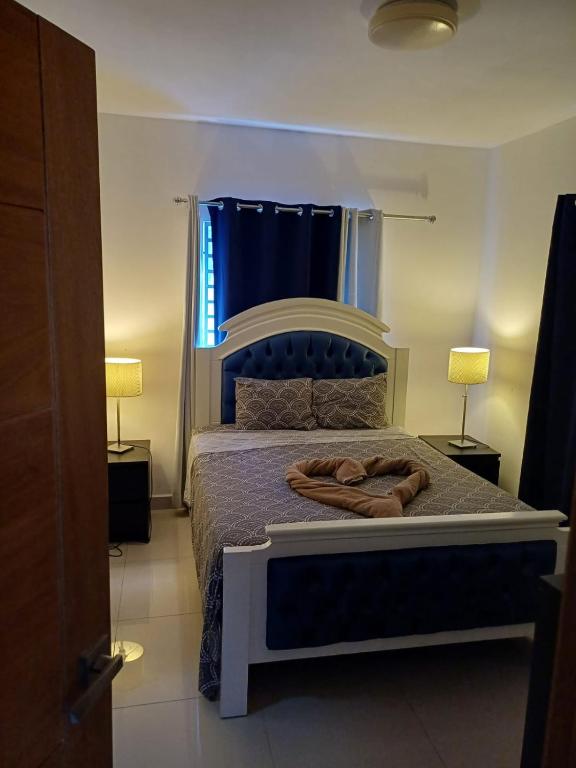 a bedroom with a large bed with two lamps at Rolando share apart in Punta Cana