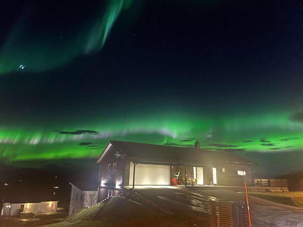 a house with the northern lights in the sky at Bardufoss Panorama in Bardufoss