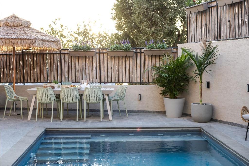 a patio with a table and chairs next to a pool at Sun Circle - וילה יוקרתית עם בריכה מול הכנרת in Poriyya