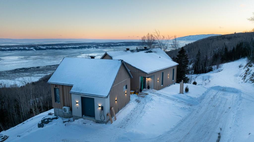a house in the snow with lights on it at La Bergerie in Saint-Joseph-de-la-Rive