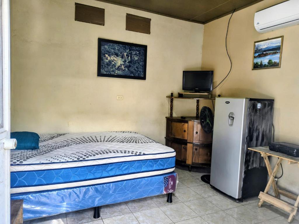 a bedroom with a bed and a refrigerator at Apartamentos Emanuel in San Benito