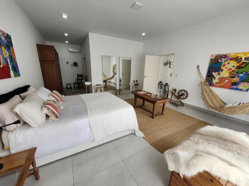 a bedroom with a large white bed and a hammock at Chácara Segredo in Bonito