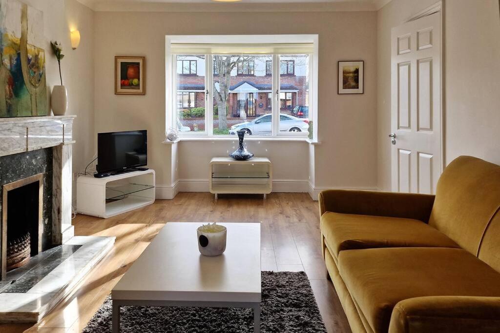 a living room with a couch and a fireplace at 2 minute walk to LUAS (tram) in Dublin