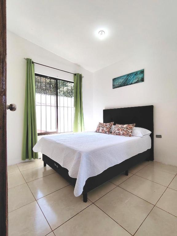 a bedroom with a bed and a large window at Casa Chika, Playa Grande, Private House, Pool, Kitchen, AC in Cuajiniquil