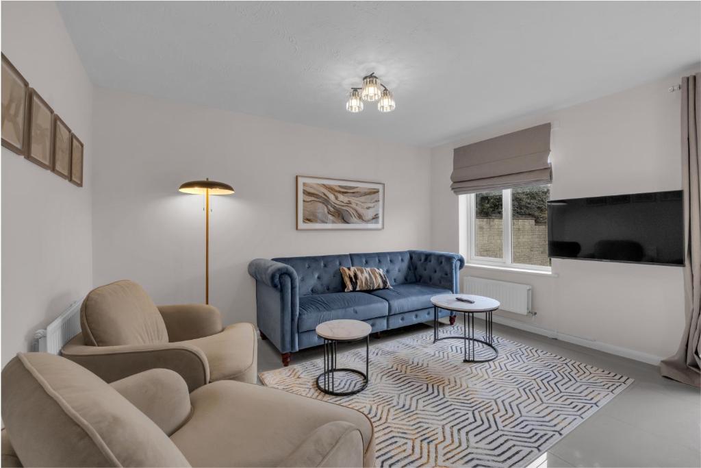 a living room with a blue couch and chairs at Modern 3 BR House near Bicester Village in Bicester