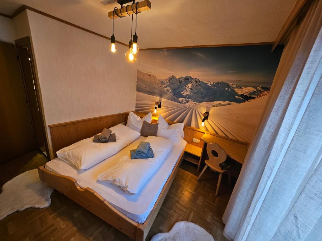 a bedroom with a bed with a painting on the wall at GG Haus Zillertal in Finkenberg