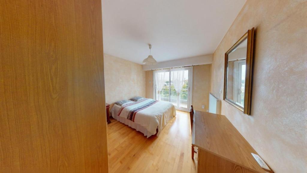 ein Schlafzimmer mit einem Bett und einem großen Fenster in der Unterkunft Djimmy hébergement in Saint-Herblain