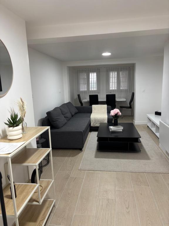 a living room with a couch and a table at Charmant Rez de Jardin 6 p 2 chambres et Parking in Savigny-sur-Orge