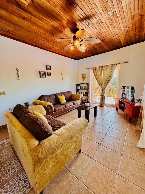 a living room with a couch and a ceiling fan at Sunset Views Apartment, West End in West End