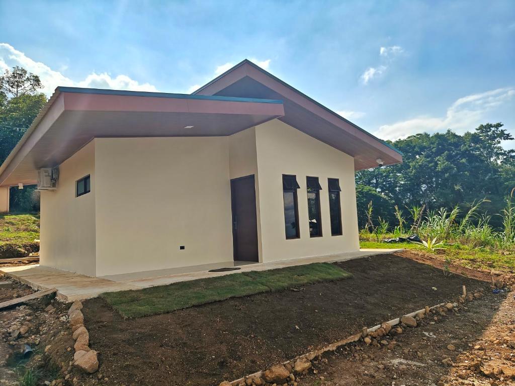 a small white house with a driveway at Casa Lapa in Aguas Zarcas