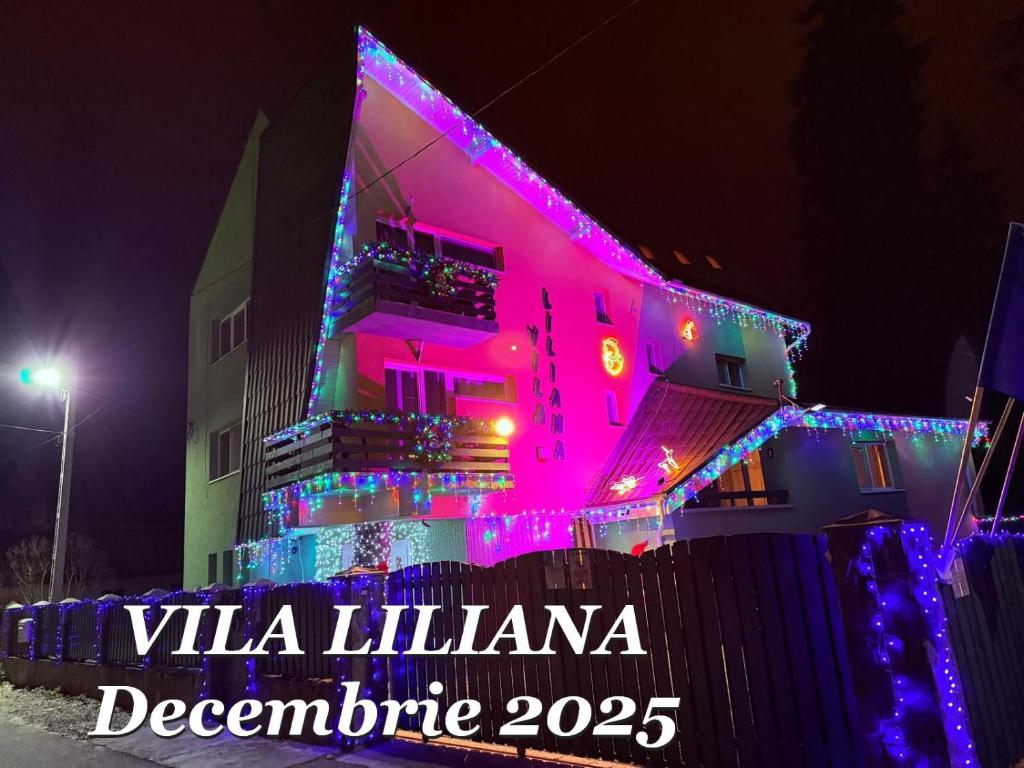 a building with christmas lights on the side of it at Vila Liliana in Predeal