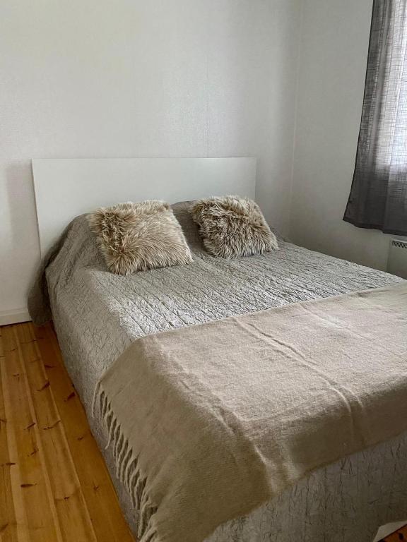 a bed with two pillows on it in a bedroom at Villa Adalia in Kalajoki