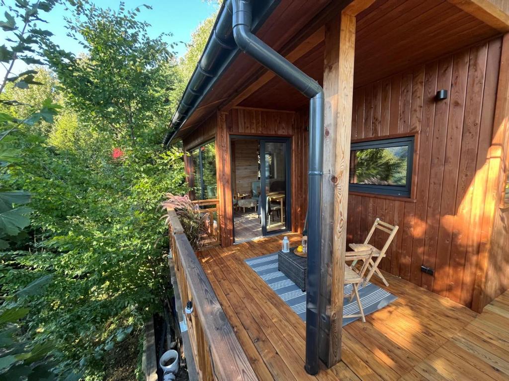 a cabin with a wooden deck with a porch at Domek nad jeziorem w górach in Międzybrodzie Bialskie