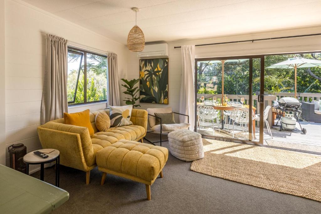 Blissful on Bay by Waiheke Pure في Waiheke Island: غرفة معيشة بأثاث أصفر وفناء