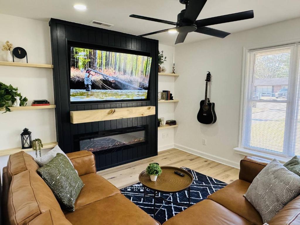 a living room with a couch and a flat screen tv at Redbud Waterfront (Augusta Canal), king bed in Augusta
