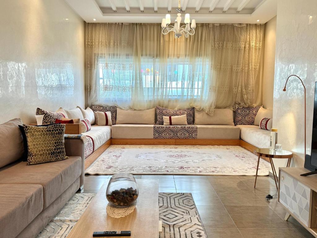 a living room with a couch and a table at Luxury and serenity HARHOURA in Temara