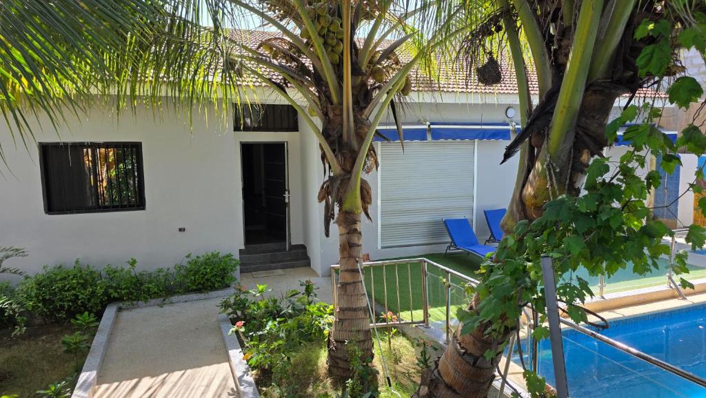 Villa Massai avec piscine au cœur de Saly في Sali Nianiaral: بيت فيه نخله ومسبح